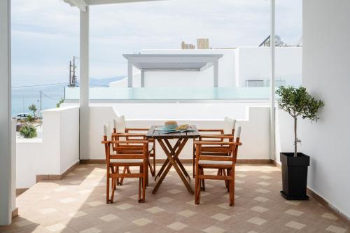 a patio with a table and chairs on a balcony at Erato Inn Naxos in Agios Prokopios