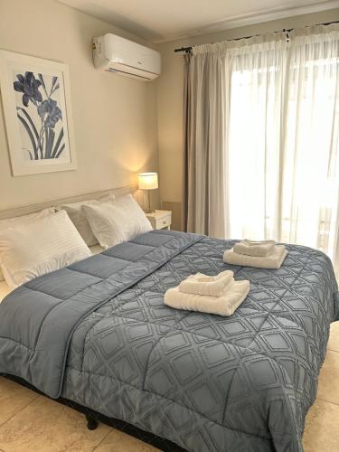 a bedroom with a bed with two towels on it at Cálidos departamentos en Ciudad con cochera in Mendoza