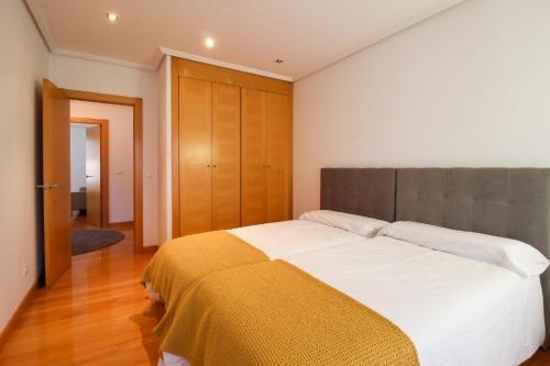 Un dormitorio con una cama grande con una manta amarilla. en El refugio home, en Santander