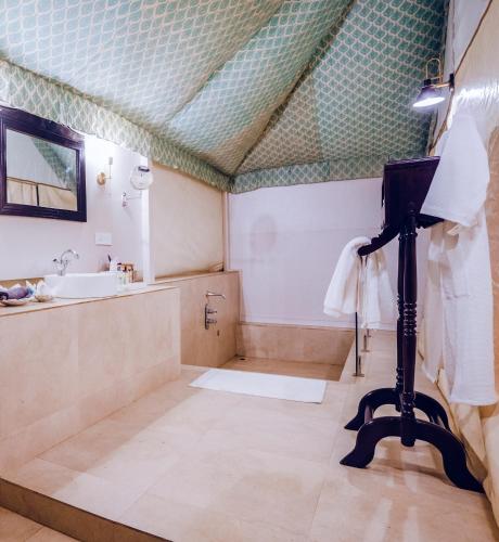a bathroom with a sink and a shower and a mirror at Angirasa Luxury Camping in Hyderabad