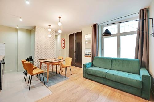 uma sala de estar com um sofá verde e uma mesa em Superb apartment 4 people center of Paris em Paris