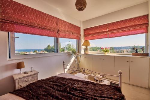 a bedroom with a bed and a large window at Villa Contessa Irini in Plános