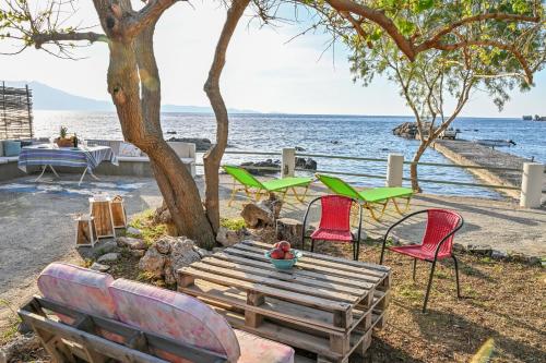 un grupo de sillas y una mesa junto al océano en Seaside House in Ravdouha, en Ravdhoúkha