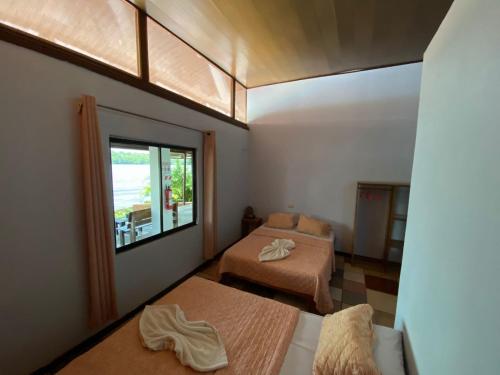 a room with two beds and a window at Hotel Sunset Rooms in Tortuguero