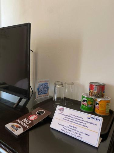 a desk with a tv and a sign on it at Nacazcol - Playas del Coco in Coco