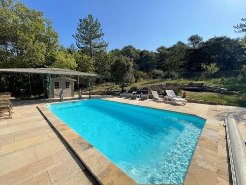 a swimming pool in a yard with chairs and a house at Gîtes Bois-Mariage in Veaux