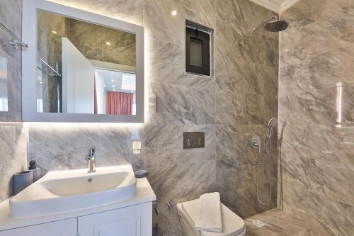 een badkamer met een wastafel, een spiegel en een douche bij Villa Likya Honeymoon in Kalkan