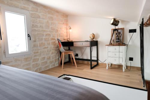 een slaapkamer met een bureau, een tafel en een stoel bij Appartement sous les toits in Antibes