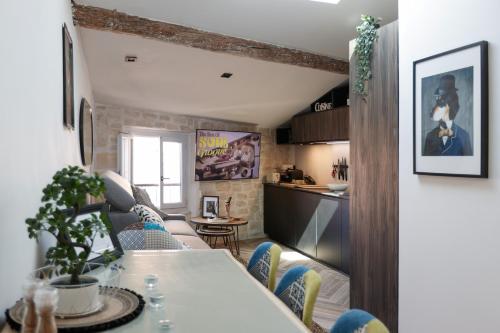 een keuken en een woonkamer met een tafel en stoelen bij Appartement sous les toits in Antibes