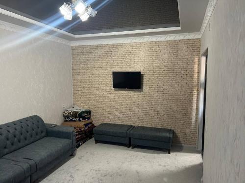 sala de estar con sofá y pared de ladrillo en Ancient Khiva Apartment, en Khiva