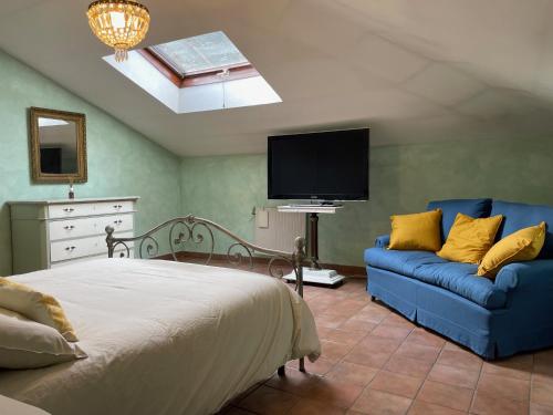 a bedroom with a bed and a couch and a tv at Appartamento castelli Romani - con vista su ROMA in Monte Porzio Catone