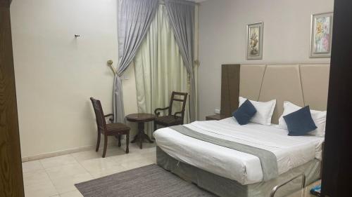 Habitación de hotel con cama, mesa y sillas en فندق اوقات الراحة للوحدات السكنيه, en Tabuk