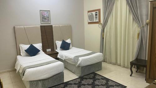 a hotel room with two beds and a television at مسكن راحتك للشقق المخدومه in Tabuk