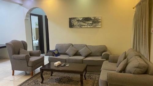 a living room with a couch and two chairs and a table at مسكن راحتك للشقق المخدومه in Tabuk