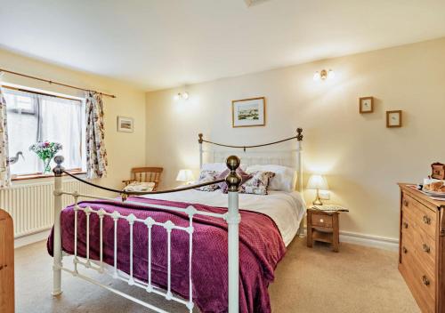 a bedroom with a bed and a dresser and a window at The White Horse Cottage in Saint James