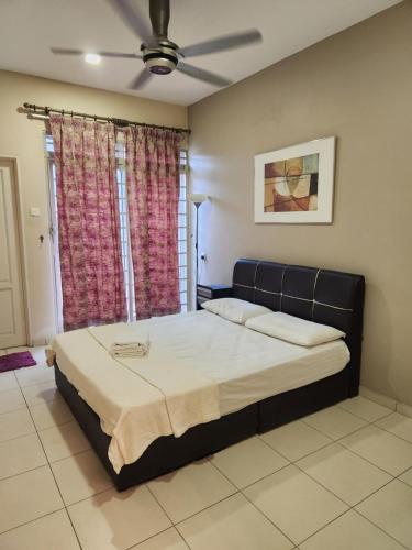 a bedroom with a bed and a ceiling fan at Bougainvillea Botani Home in Ipoh