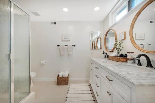 - une salle de bains blanche avec deux lavabos et une douche dans l'établissement Conejo Oasis, à Thousand Oaks