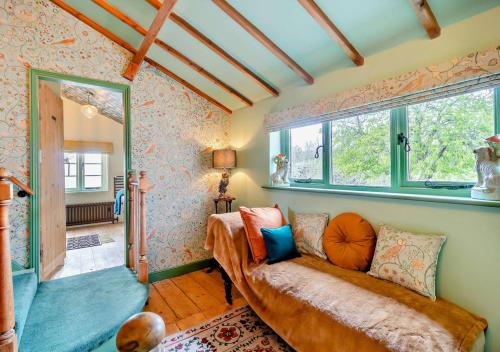 - un salon avec un canapé et une fenêtre dans l'établissement Town Cottage, à Halesworth