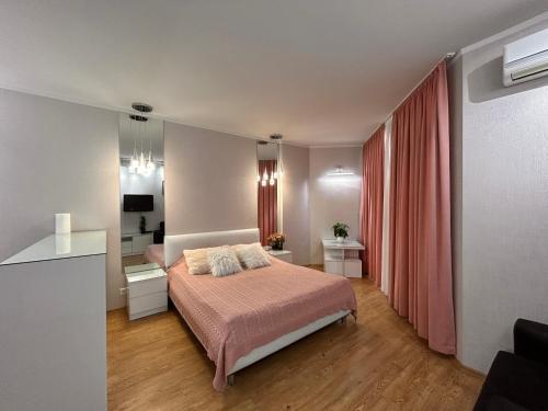 a bedroom with a bed and a red curtain at Black Sea Apartament in Batumi