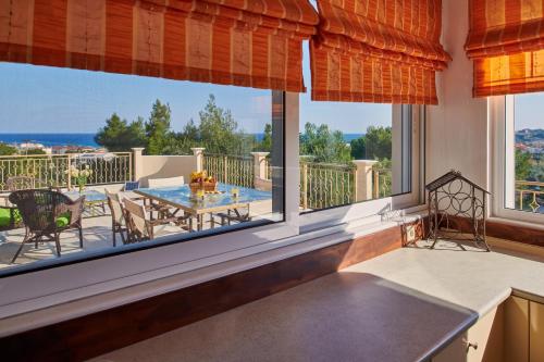 a kitchen with large windows and a table and chairs at Villa Contessa Irini in Plános
