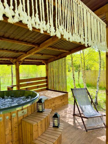 a wooden deck with a hot tub and a bench at Domek nad Zegrzem in Arciechow