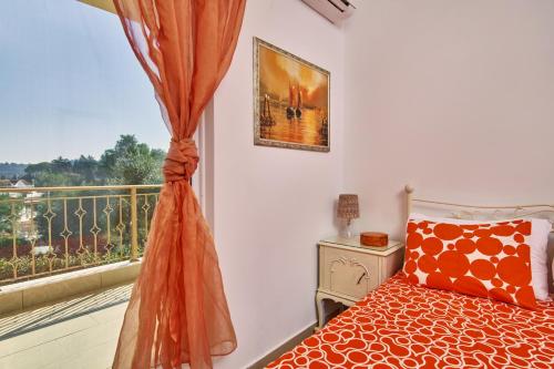 a bedroom with a bed and a balcony with a window at Villa Contessa Irini in Plános