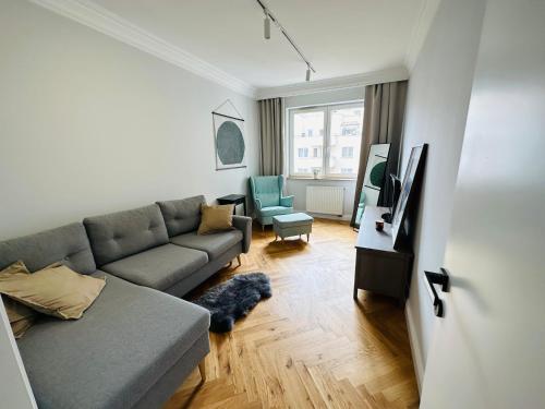 sala de estar con sofá y TV en Warsaw Sadyba Premium Apartment by B2, en Varsovia