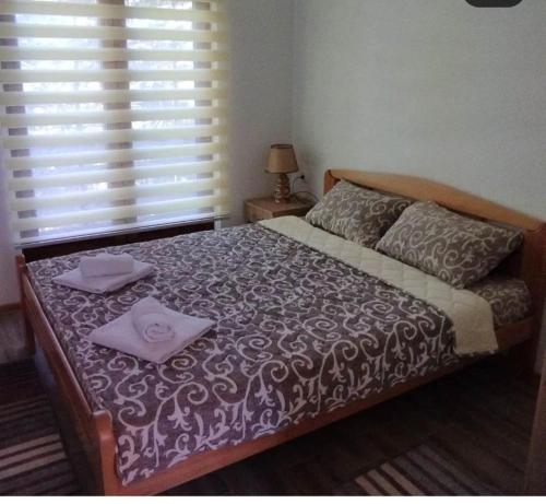 a bedroom with a bed with two towels on it at Apartman NIKOLIJA 2 in Kaludjerske Bare