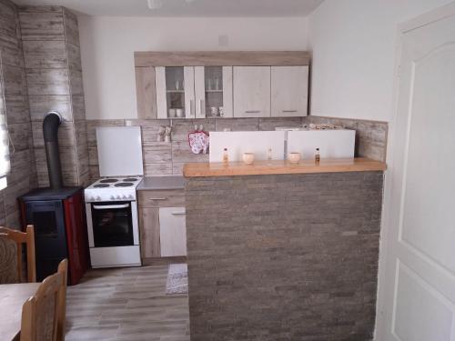 a kitchen with white cabinets and a brick wall at Apartman NIKOLIJA 2 in Kaludjerske Bare