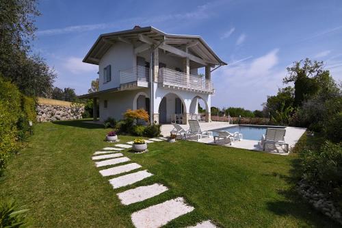 a house with a swimming pool in the yard at Villa Bocciolo del Garda in Manerba del Garda