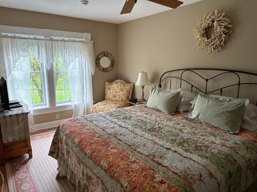 um quarto com uma cama grande e uma janela em Maple Shade Bed & Breakfast 