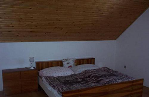 - une chambre avec un lit et un plafond en bois dans l'établissement Ubytování v Jeseníkách - Bělá pod Pradědem, à Adolfovice