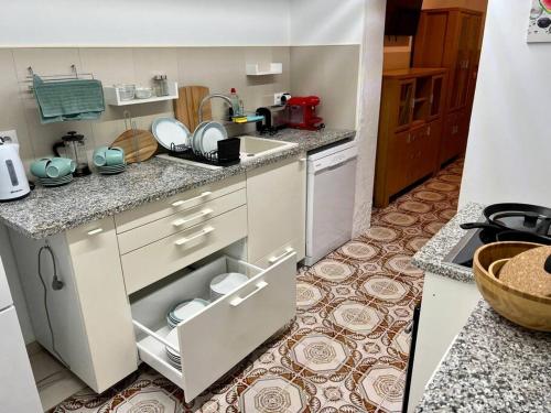 a kitchen with white cabinets and a counter top at Casa Brisa del mar in Puerto de Sagunto