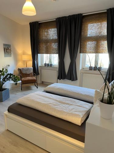 een slaapkamer met een groot bed en zwarte gordijnen bij Apartment Am Petersberg Erfurt in Erfurt
