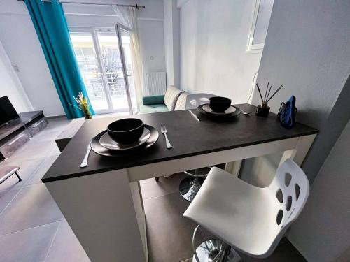 una cucina con tavolo con due tazze e una sedia di Luxury Apartment in the City Center & Free Parking a Volos