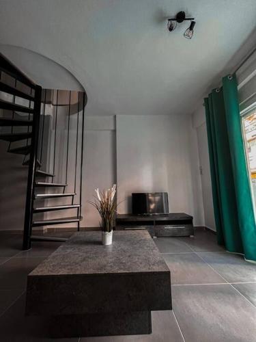 a living room with a table and a television at Escala Luxury Loft 3 in the Center & Free Parking in Volos