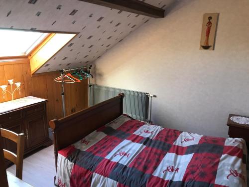 - une chambre avec un lit et une couverture en damier dans l'établissement Gite du Château, à Guémar