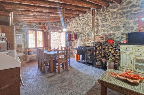 a kitchen with a table and a stove at casa rural La Fragua in Villar de Corneja