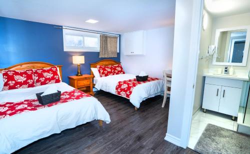 sypialnia z 2 łóżkami z czerwoną i białą pościelą w obiekcie Cozy 3BR 2Bth Lower Unit, A min to Hwy401, 404 & DVP w mieście Toronto