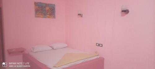 a room with a pink room with a bed in it at Palm Valley camp in Nuweiba‘ el Muzeinah
