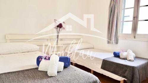 a bedroom with two beds and a vase with flowers at SA TORRETA 3 in Cala Blanca