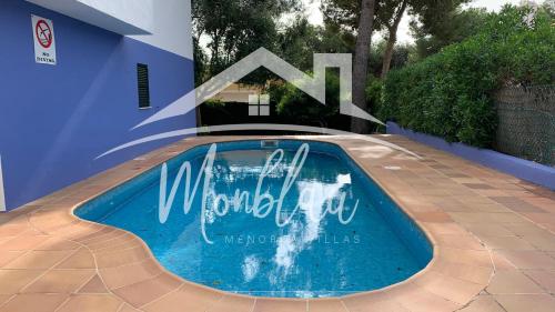 a swimming pool with a sign on the side of a house at SA TORRETA 3 in Cala Blanca
