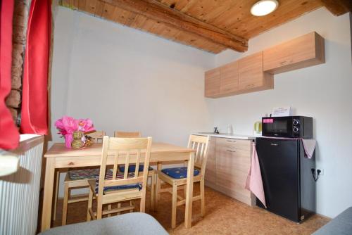 a small kitchen with a table and a refrigerator at Penzion Květná Zahrada in Květná