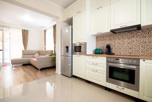 a kitchen with white cabinets and a stainless steel refrigerator at Casa de langa lac in Oradea