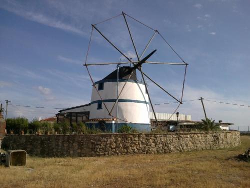 a windmill sitting on top of a stone wall at O MOINHO in Casais dos Cardosos