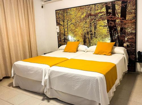 a bedroom with a large bed with yellow pillows at Hacienda Guadalquivir in Córdoba