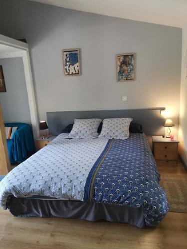 a bedroom with a large blue bed with two pillows at Gîte effet d’art in Saint-Privat