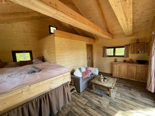 ein Schlafzimmer mit einem großen Bett in einer Holzhütte in der Unterkunft Treehouse Velké Losiny in Velké Losiny