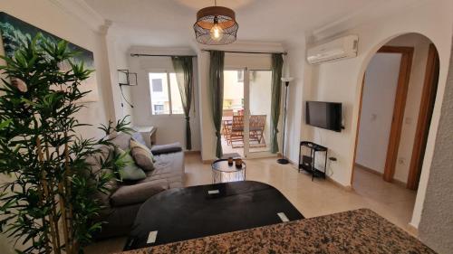 sala de estar con sofá y mesa en Lovely one bedroom unit with balcony and pool, en Denia