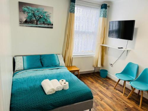 a bedroom with a bed with two towels on it at WoodGreen house in London